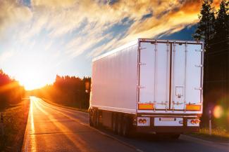 Tractor trailer transporting commercial freight driving on highway