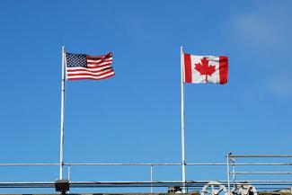 U.S. and Canadian flag flying at border