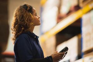 Woman using hand-held device to review shipping data
