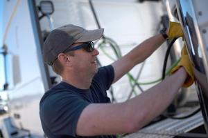 Dedicated driver examines truck