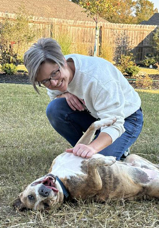 Carol Sikes and dog, Douglas, playing in the backyard 