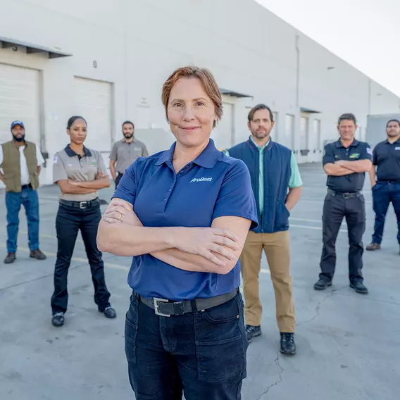 Group of male and female ArcBest drivers standing outside a service center.