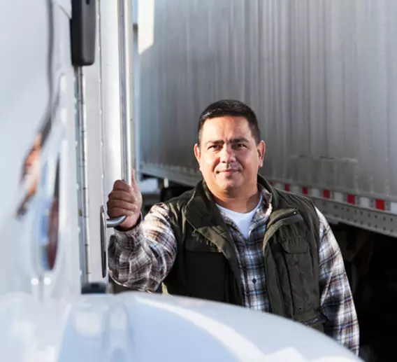 Truck driver standing beside his truck.