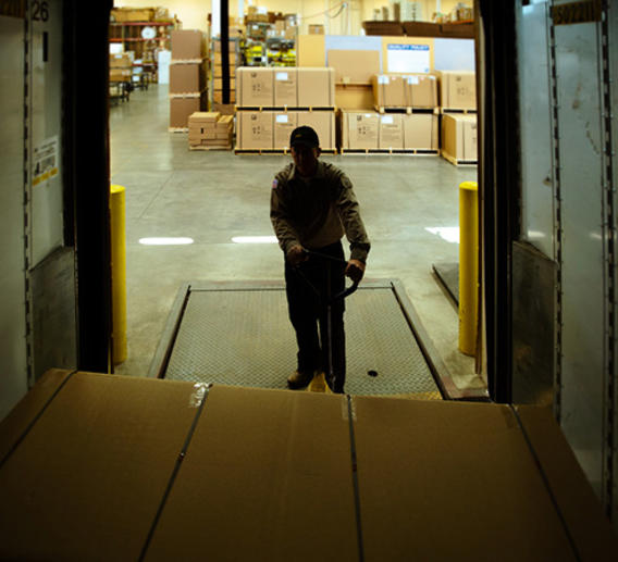 Dock worker unloading LTL freight from a trailer.