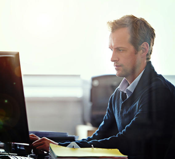 Man sitting at a computer in an office.