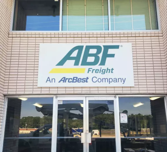 Entrance sign on brick building reading "ABF Freight, an ArcBest Company."