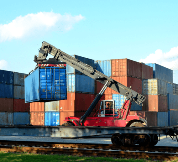 Intermodal container being moved off a chassis in a rail yard.