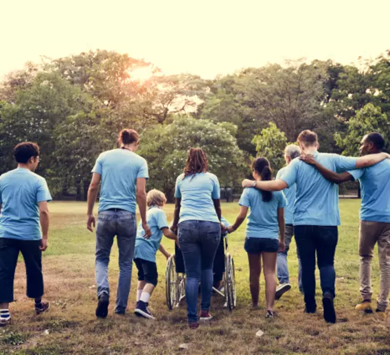 Volunteers walking away from camera with their arms around each other.