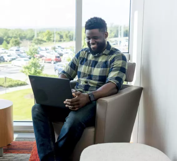 ArcBest employee working in a breakout room in front of a window.