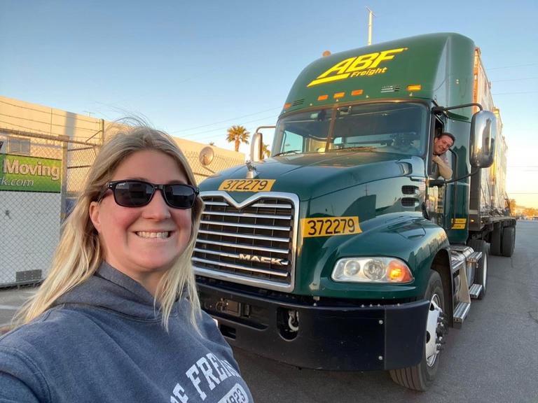 [Brianna Wasko] Brianna Wasko, the first female named to the 2023-2024 ABF Road Team, poses outside an ABF truck. 