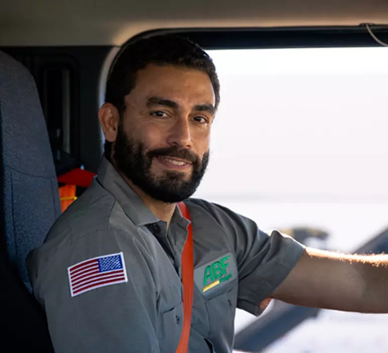 Driver sitting in tractor trailer cab beginning driving route