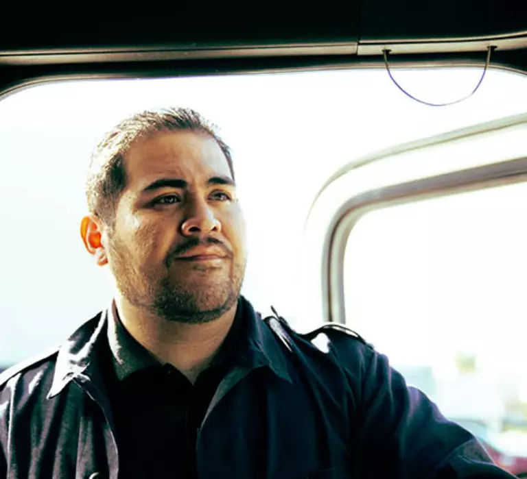 Male truck driver standing in the open doorway of a Panther truck.