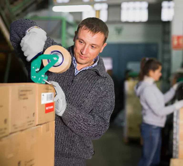 Employee taping a cardboard box