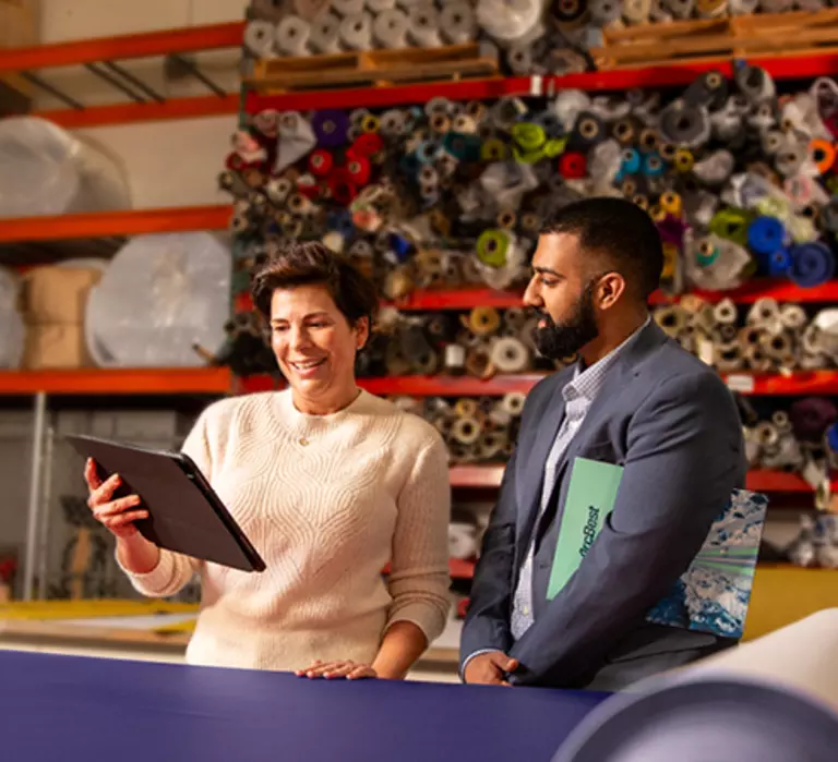 Female customer speaking with an ArcBest representative in a warehouse.