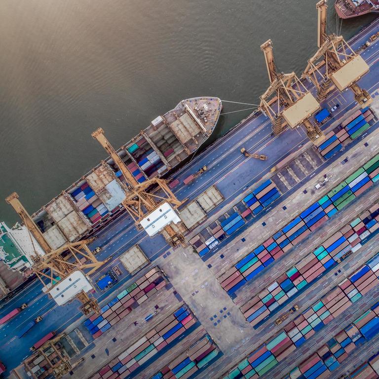 Aerial view of a boat and containers in a seaport
