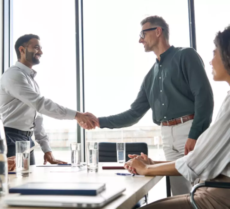 Two men shaking hands in a conference room