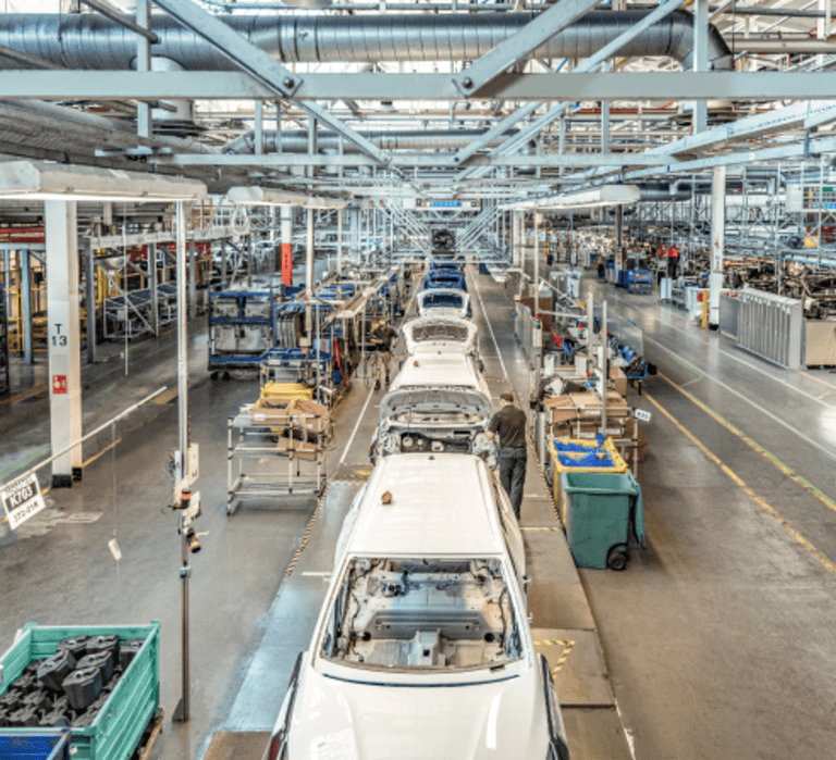 Cars being built on a production line using JIT inventory