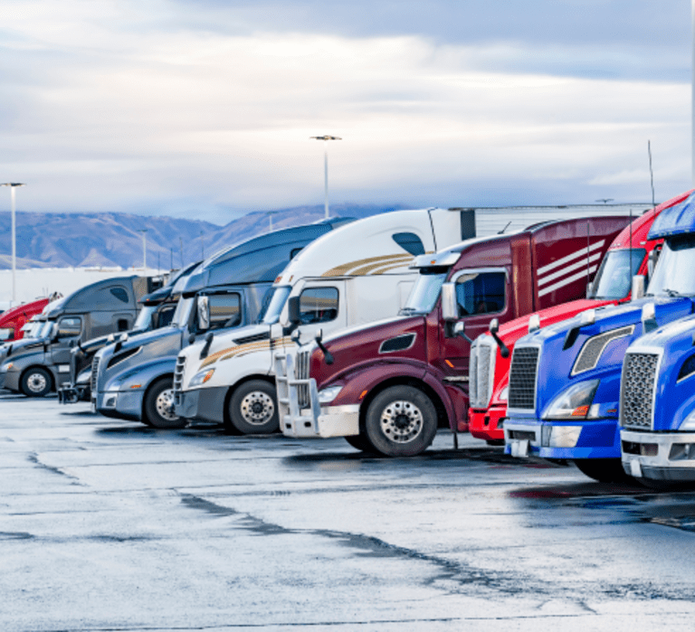Multiple LTL trucks lined up in a parking lot.
