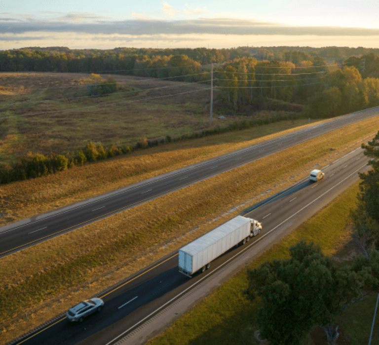 Aerial view of a highway with cars and a truck driving down it.