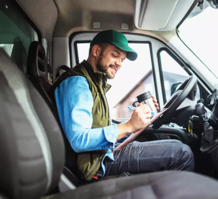 Truck driver sitting in cab of truck.