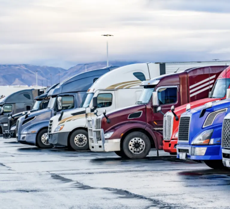 Semi Trucks lined up in a parking lot. 