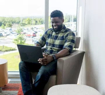 ArcBest employee working in a breakout room in front of a window.