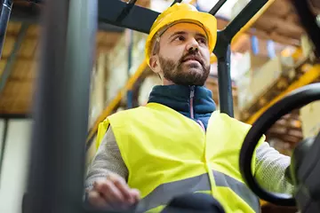 Man on forklift works to transload a shipment