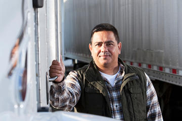 Truck driver standing beside his truck.