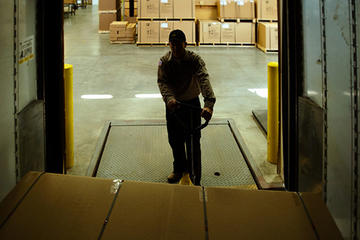 Dock worker unloading LTL freight from a trailer.