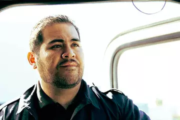 Male truck driver standing in the open doorway of a Panther truck.