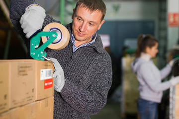 Employee taping a cardboard box
