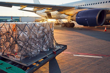 Air cargo getting ready to be loaded into a plane on a runway.