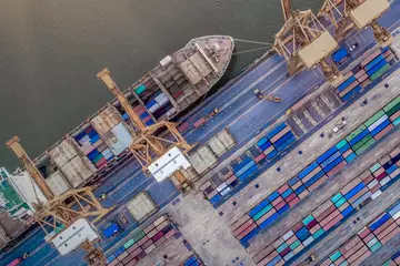 Aerial view of a boat and containers in a seaport