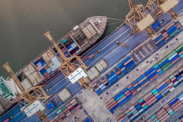 Aerial view of a boat and containers in a seaport
