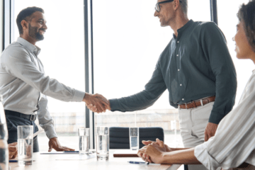 Two men shaking hands in a conference room