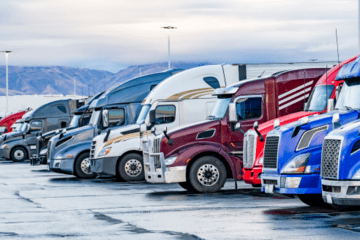 Multiple LTL trucks lined up in a parking lot.