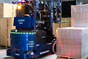 Vaux Smart Autonomy forklift next to pallets in a warehouse.