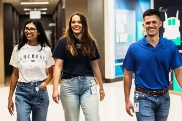 Three ArcBest employees walking down a hallway at the office.