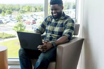 ArcBest employee working in a breakout room in front of a window.