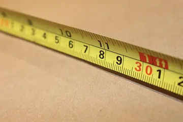 Tape measure being used to measure a box.