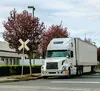 White semi-truck stopped at a railroad crossing