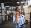 Woman standing in a warehouse on the phone with an expedite shipper