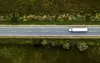 Aerial view of a truck driving on a highway, right to left.